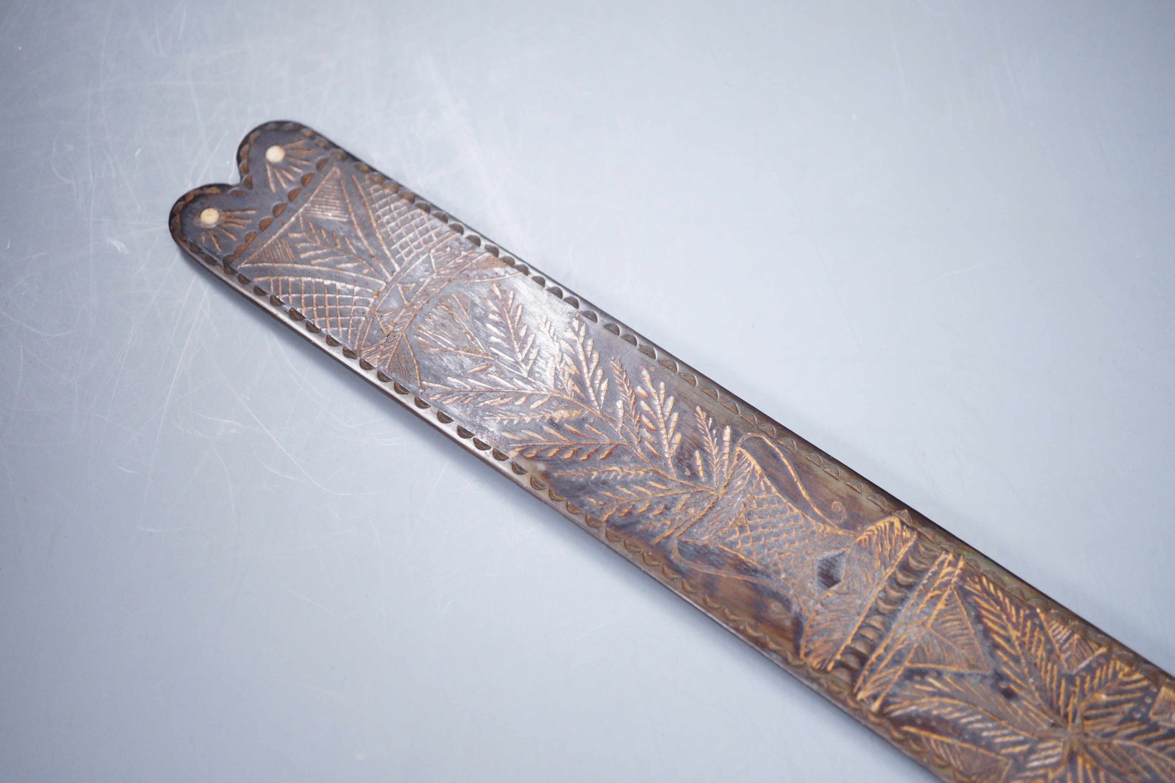 A 19th century carved horn page turner with bone inset roundels, 30.5cm